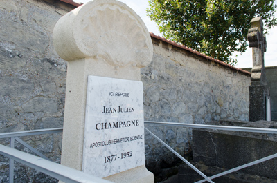 Tombe de Julien Champagne - vue de trois-quarts avec le cimetière en arrière-plan